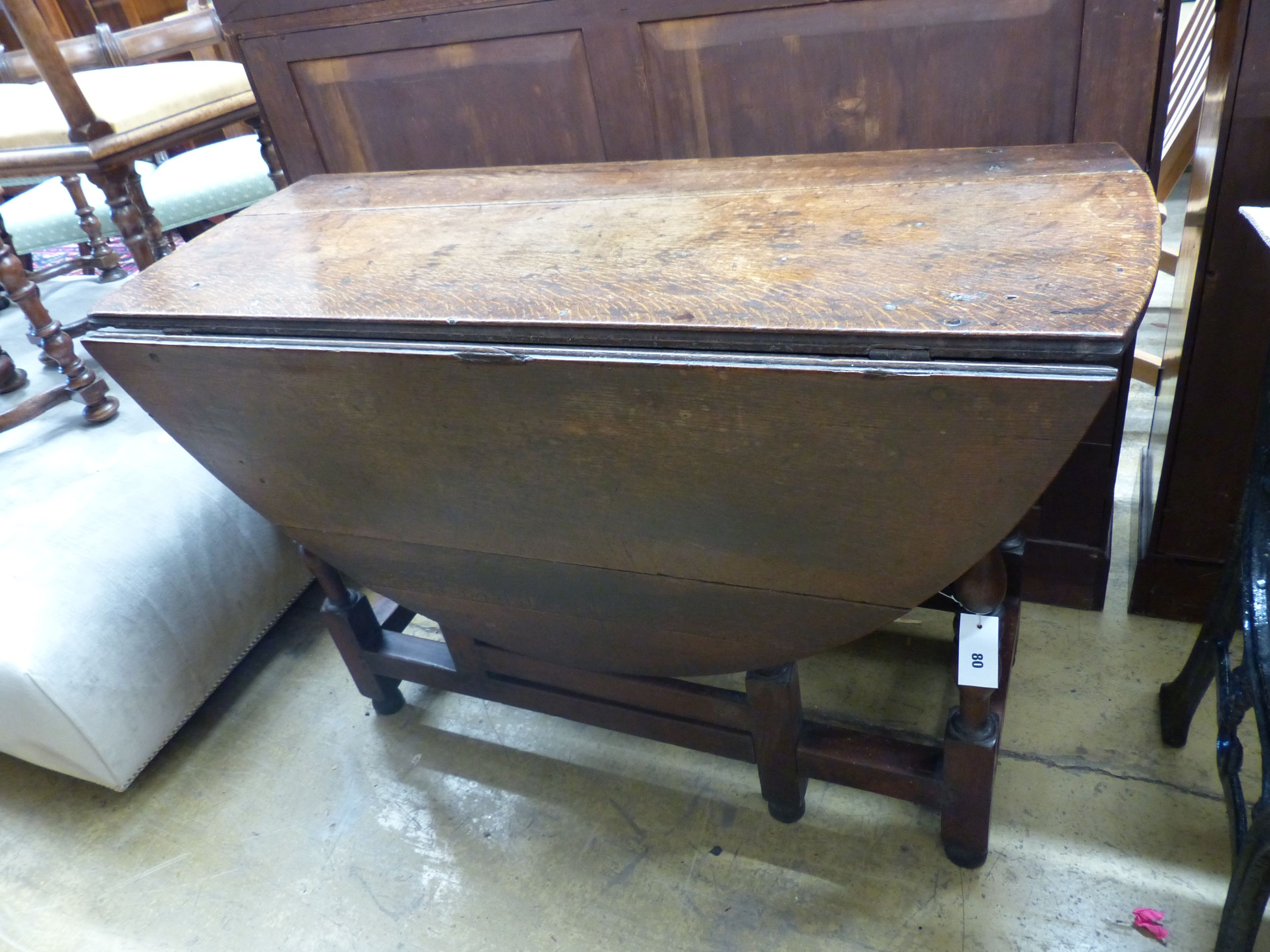 An 18th century oval oak gateleg dining table, length 135cm extended, width 114cm, height 75cm